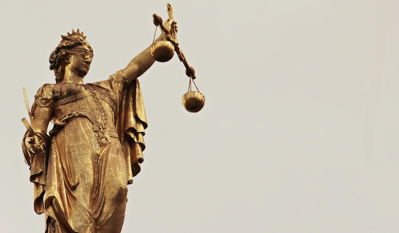 Justitia was the Roman goddess of justice and order, often depicted with scales, a sword, and sometimes a blindfold. This image is used to represent the recent attack on the legal aid agency