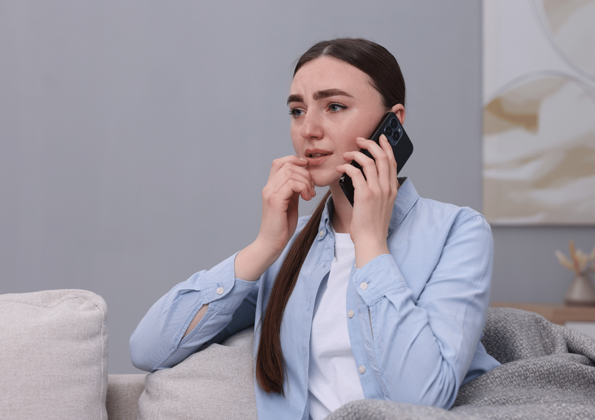Woman seeking domestic abuse support by phone in a safe environment